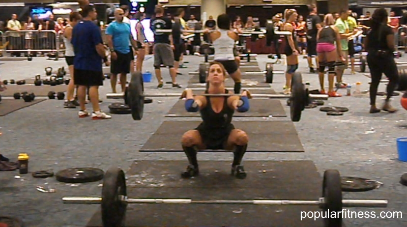 Woman powerlifting barbell at fitness competition