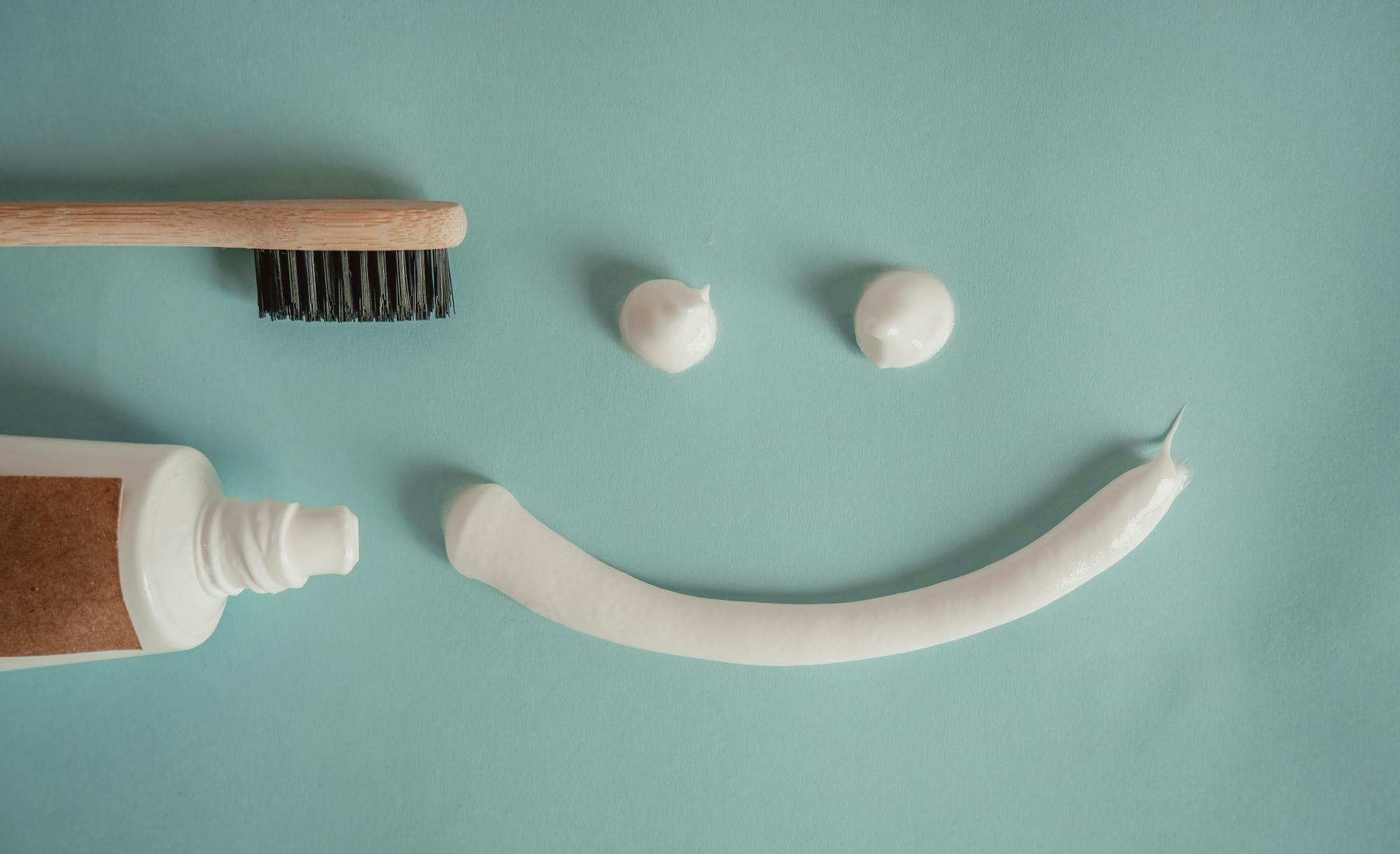 Tothbrush, tube of toothpaste and a toothpaste smaile