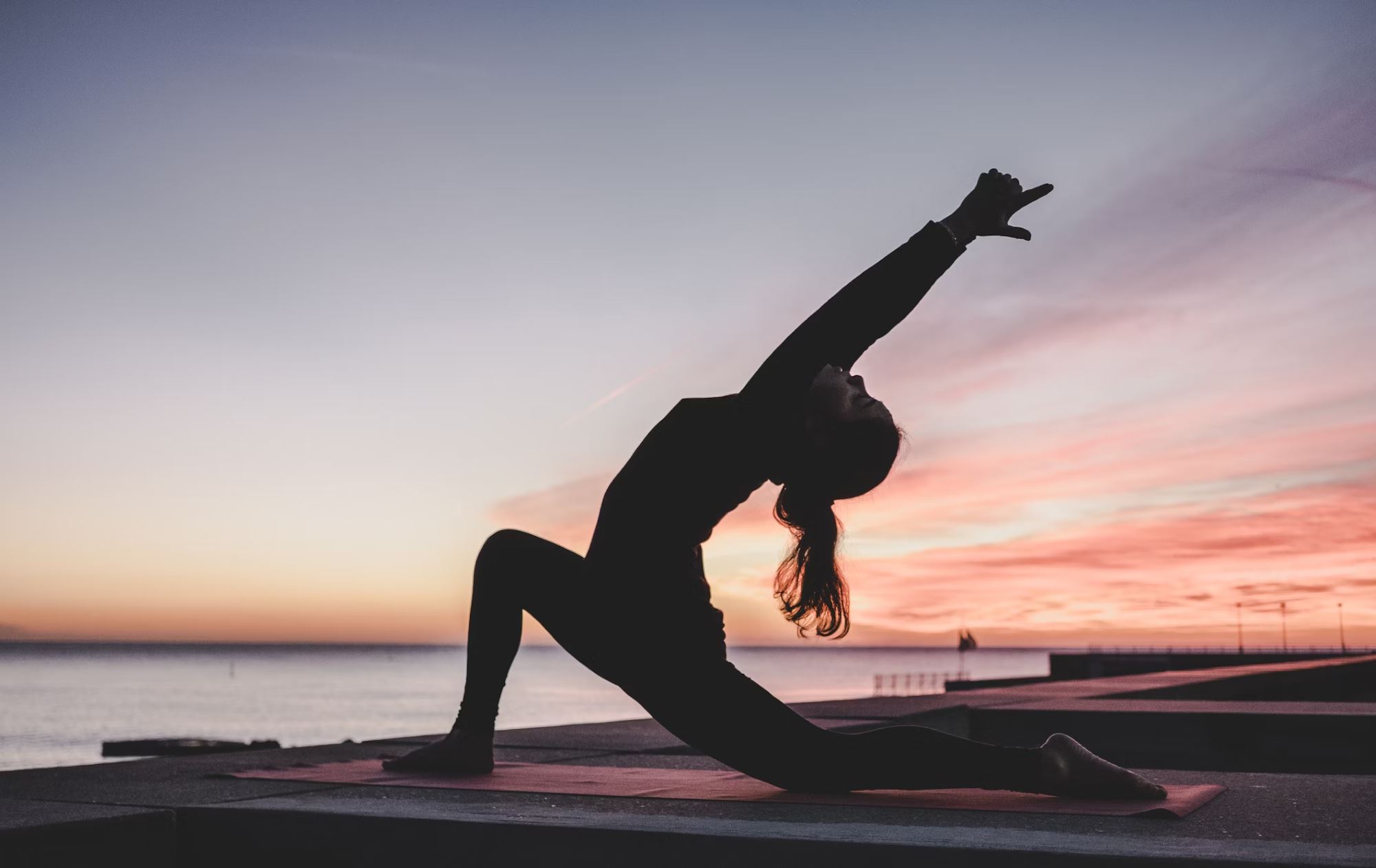 A woman doing yoga exercise, yoga pose during a sunset.