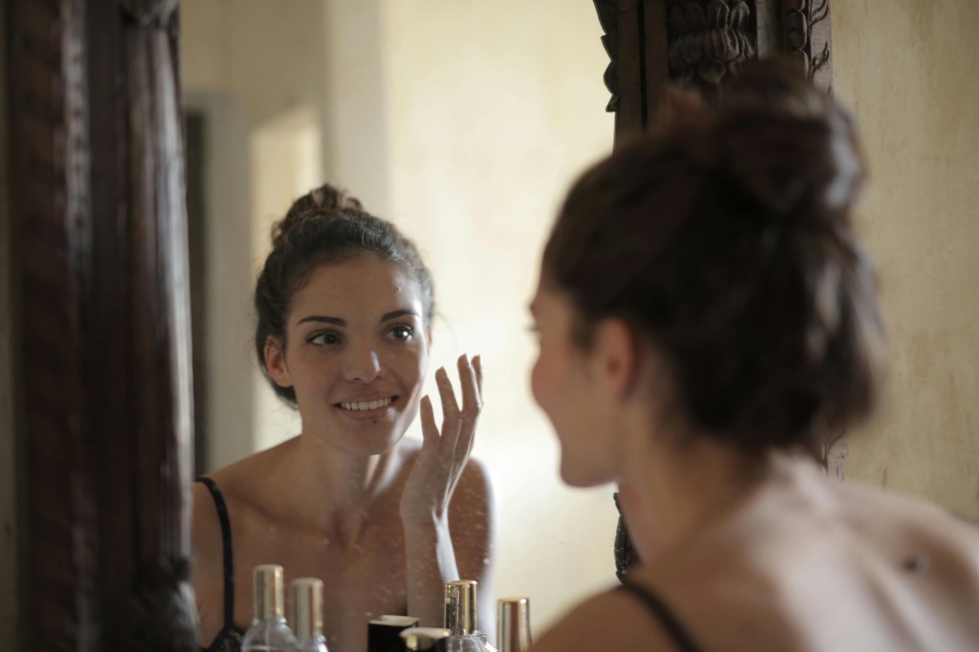 Woman looking at her appearance in th mirror.